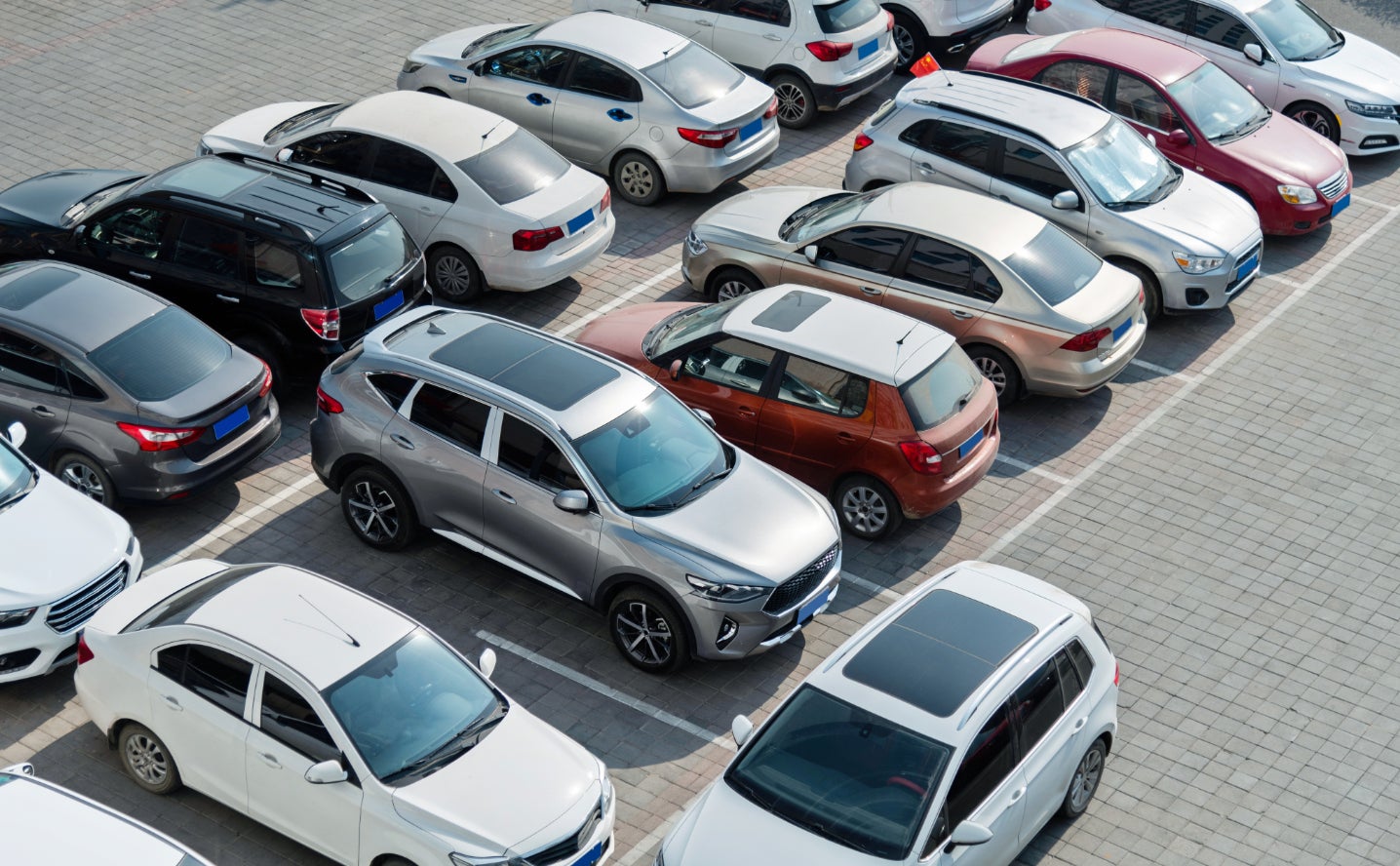 An overhead view of a variety of used cars in a parking lot.