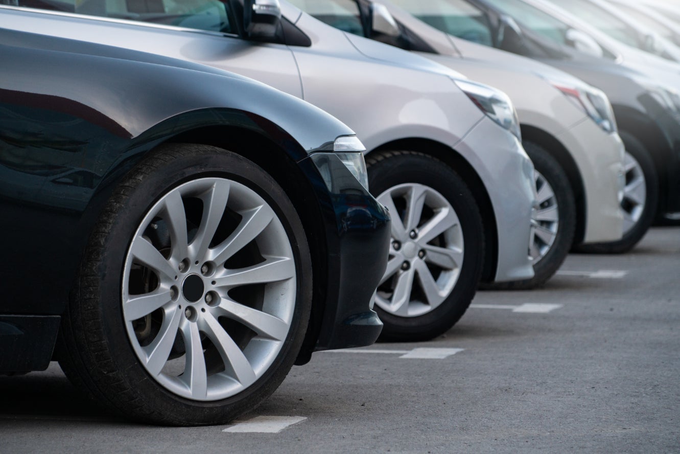 A view of the front part of a row of cars in a dealership lot