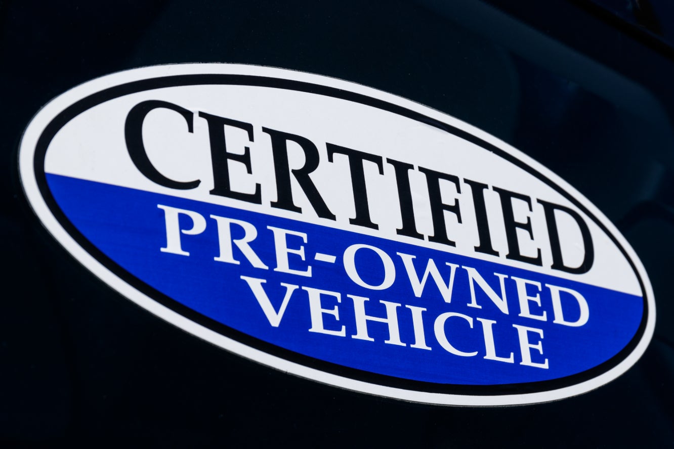 A certified pre-owned vehicle sticker on a car's window.